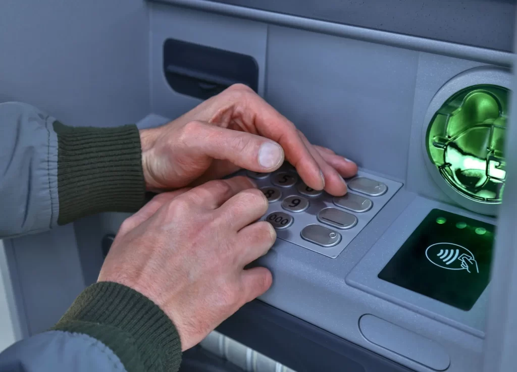 Shutterstock_1324154378 - Techsvět Muž zadává PIN u bankomatu