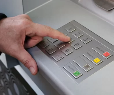 Muž zadává PIN u bankomatu