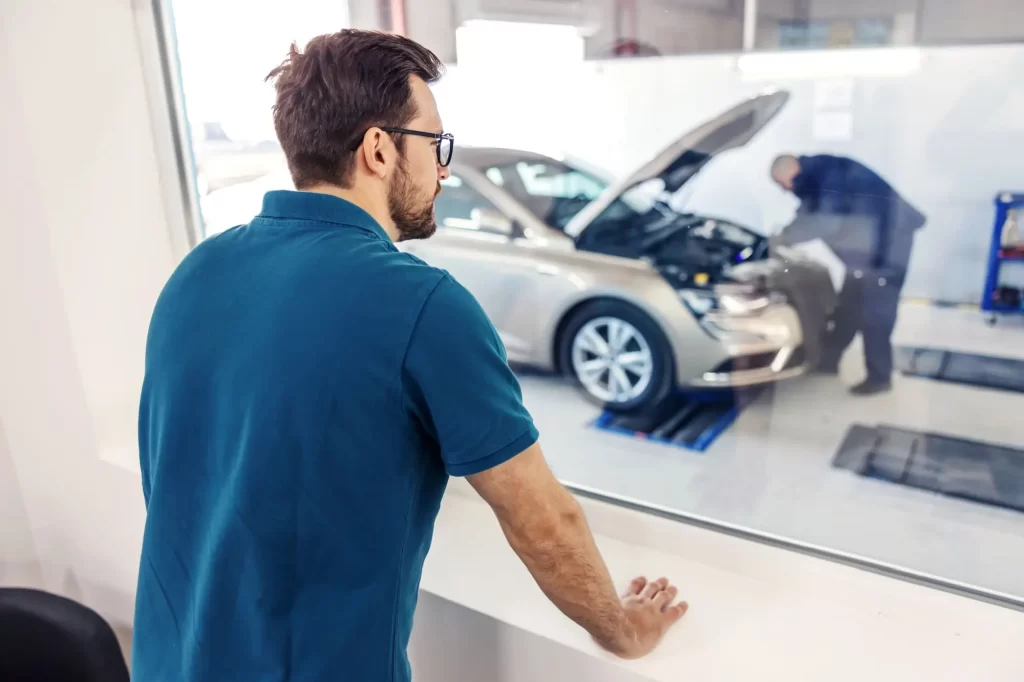 Technická prohlídka auta na STK zabere nemalé množství času - Techsvět Muž kontroluje auto