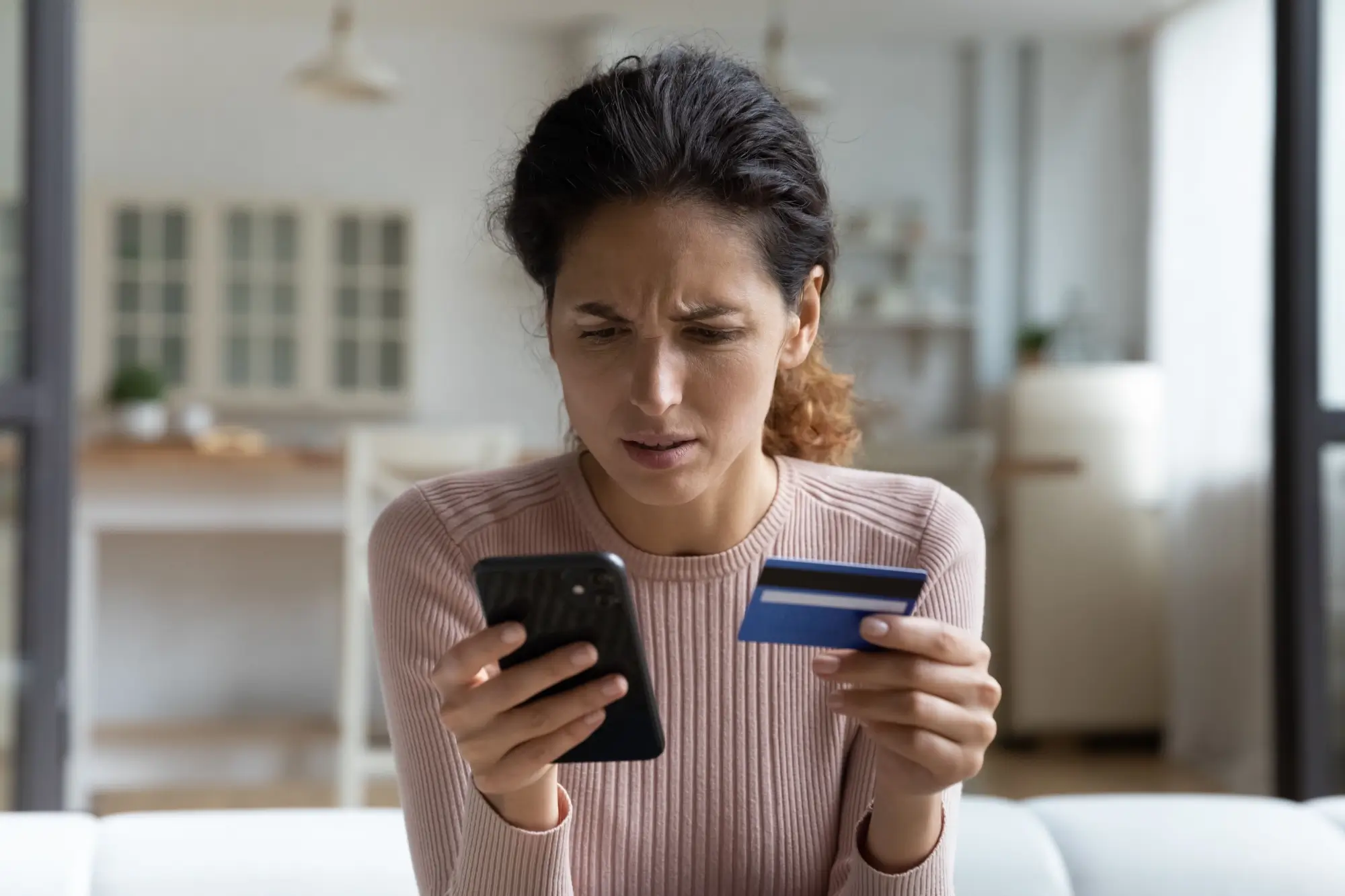 Žena zadává číslo své platební karty do telefonu 