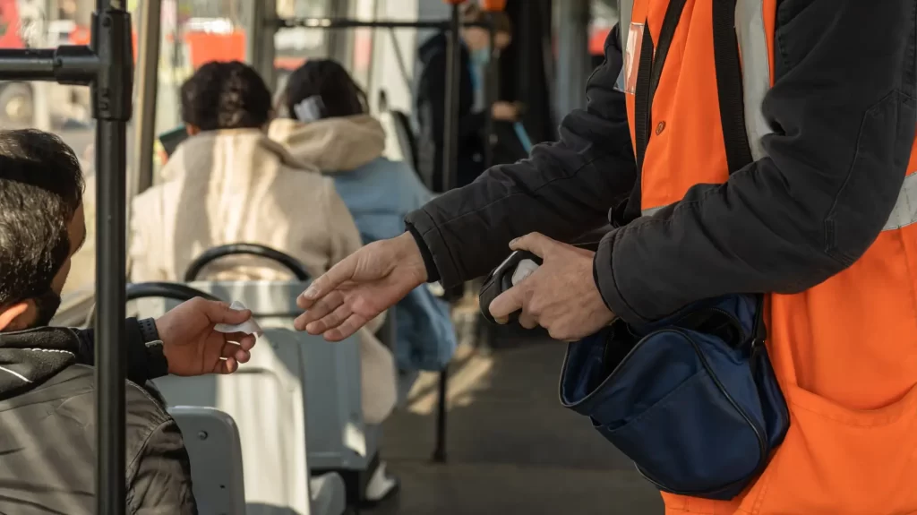 Pasažér dává revizorovi jízdenku