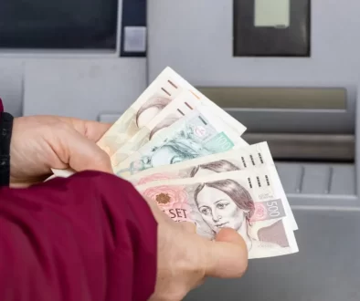 Žena vkládá peníze do bankomatu