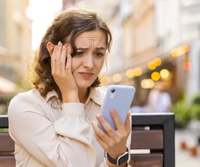 Žena nervózně kouká do telefonu