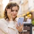 Žena nervózně kouká do telefonu