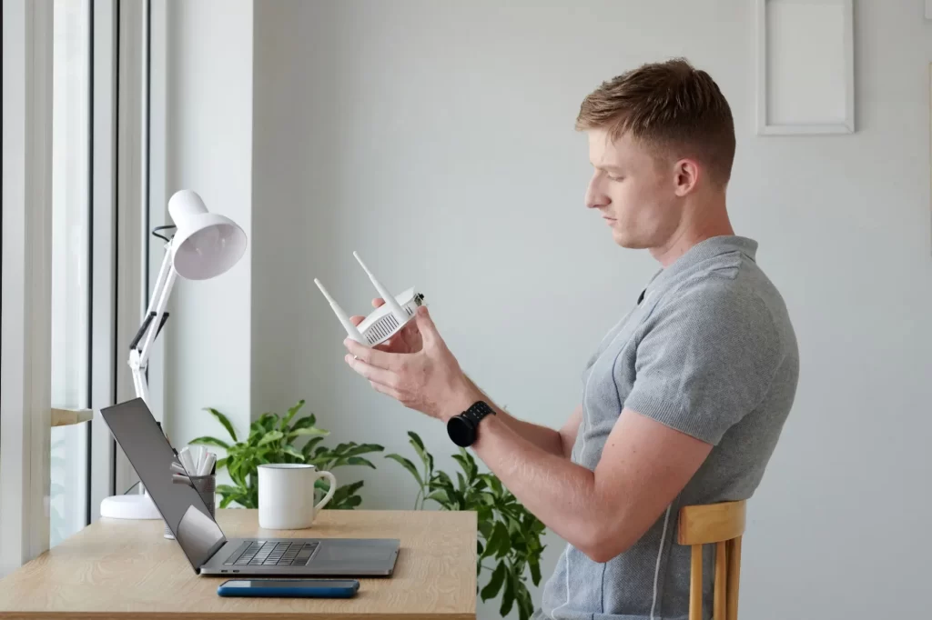 Přihlašovací údaje k nastavení najdete na zadní straně routeru, FOTO: Shutterstock - Techsvět muž nastavuje router
