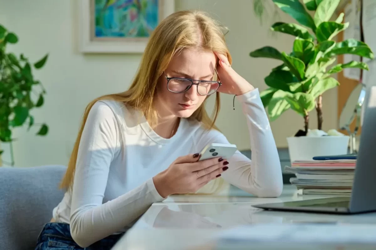 Dívka přemýšlí s mobilem