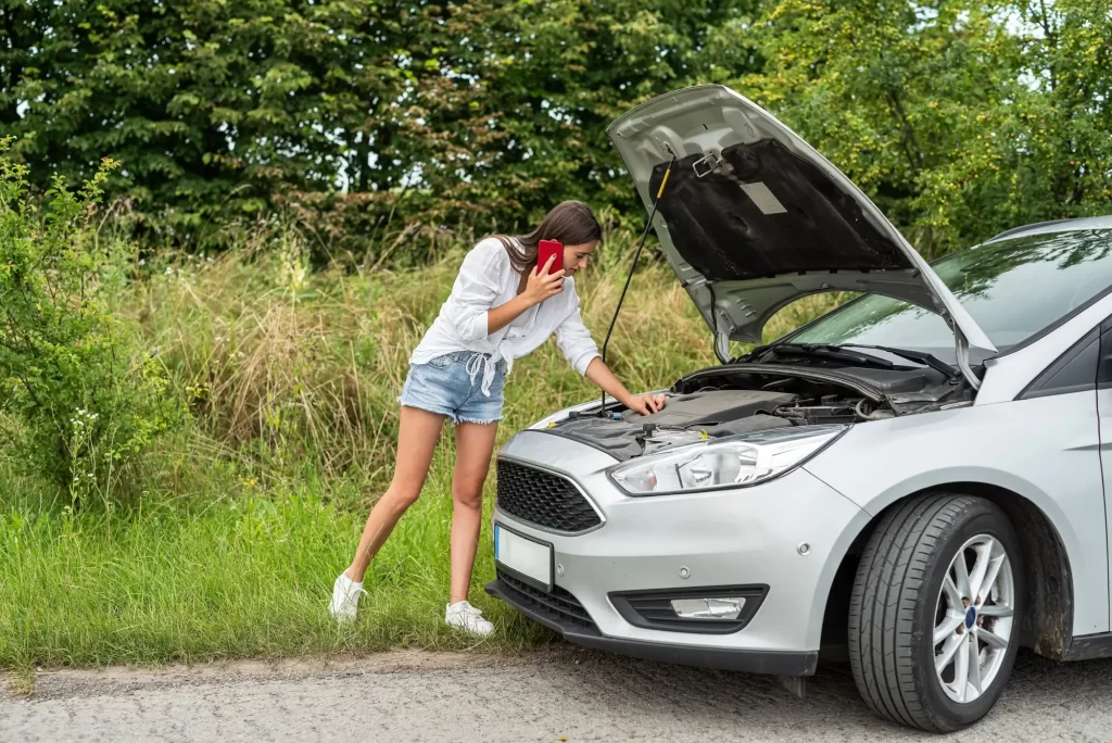 Shutterstock_2447086091 - Techsvět Žena stojí u otevřené kapoty auta