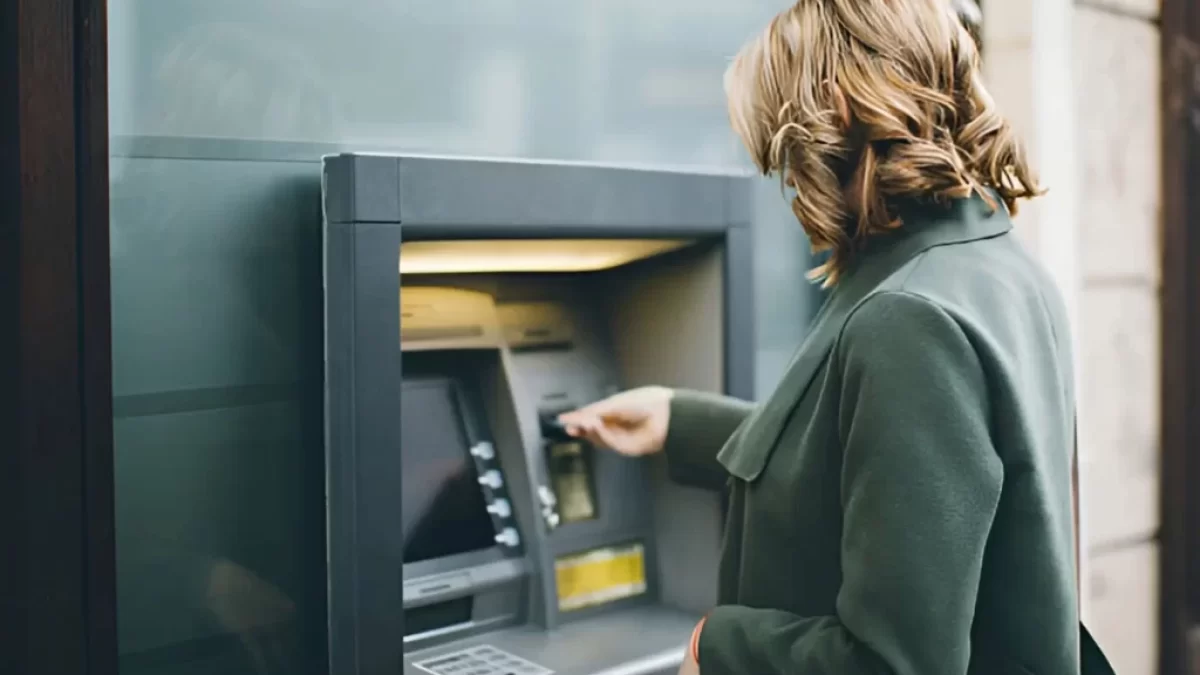 Žena vybírá z bankomatu