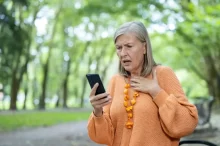 starší žena kouká do telefonu