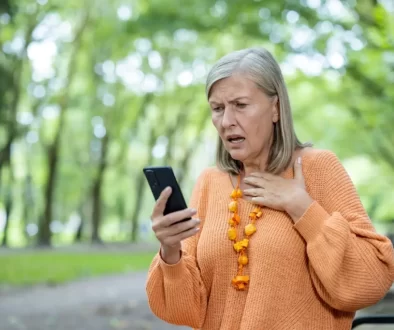 starší žena kouká do telefonu