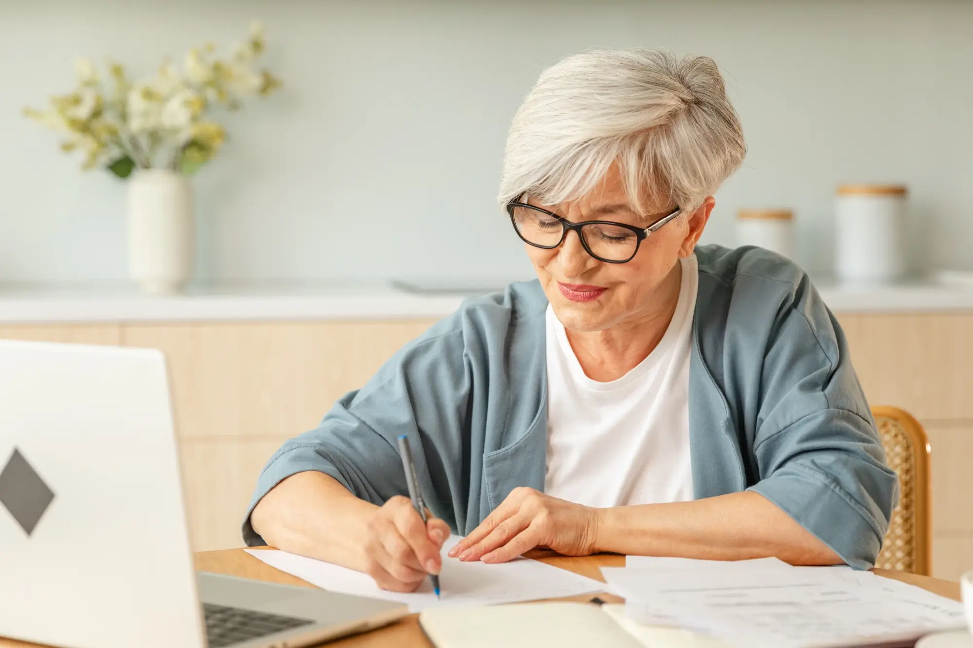 Shutterstock_2531829785 - Techsvět Seniorka u stolu počítá