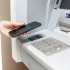 Žena přikládá telefon k bankomatu