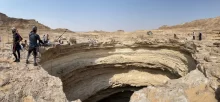 Studna Barhút (známá také jako Pekelná jáma) v Jemenu. U okraje propasti stojí skupina speleologů vybavená horolezeckým vybavením, kteří se připravují na sestup do hlubin.