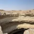 Studna Barhút (známá také jako Pekelná jáma) v Jemenu. U okraje propasti stojí skupina speleologů vybavená horolezeckým vybavením, kteří se připravují na sestup do hlubin.
