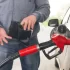 Muž u benzínové stanice tankuje a dívá se do prázdné peněženky