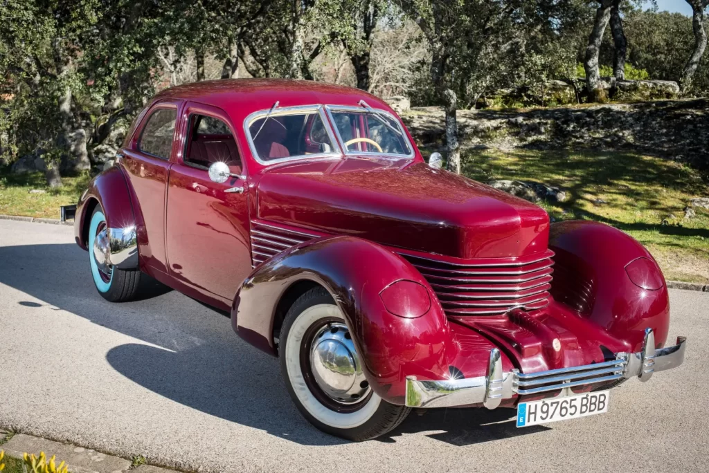 gaz3 - Techsvět Americký vůz Cord 810 z druhé poloviny 30. let zaparkovaný na slunné příjezdové cestě.