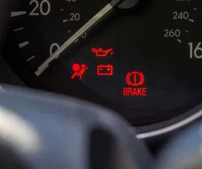 Detail palubní desky automobilu s několika rozsvícenými výstražnými kontrolkami.