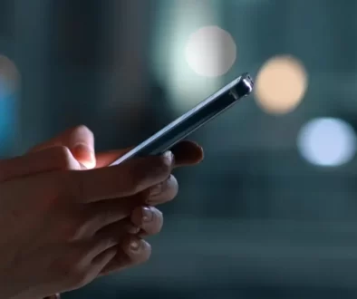Detail rukou držících chytrý telefon.