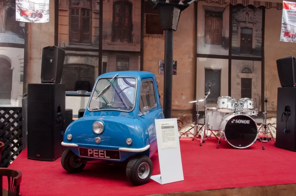 peel2 - Techsvět Peel P50 v ikonickém modrém provedení, vystavený na červeném koberci.