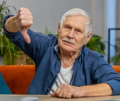 Senior v modré košili ukazuje palec dolů