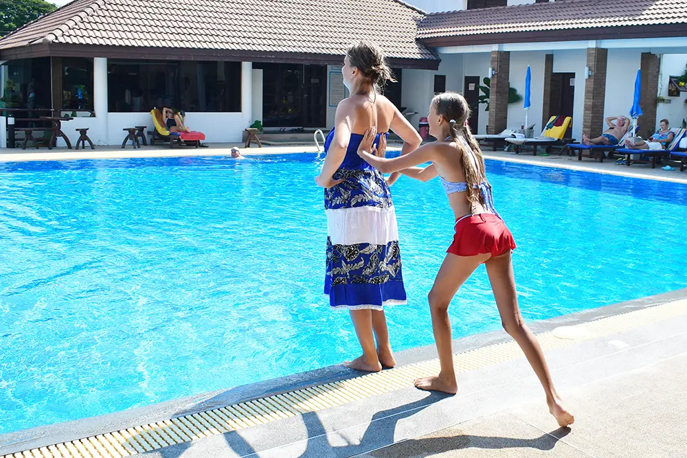 Lidé ve střední třídě navštěvují kulturní akce, věnují se sportovním aktivitám a jezdí na dovolenou. - Techsvět rodina u bazénu na dovolené