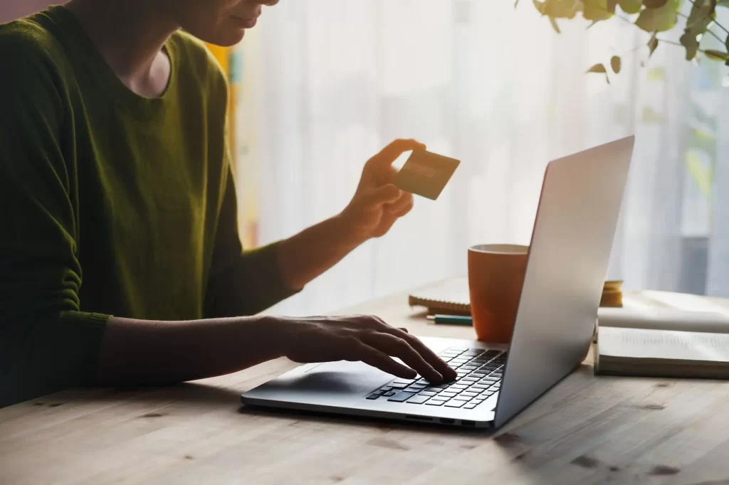 shutterstock_1879309885 - Techsvět žena u notebooku s platební kartou