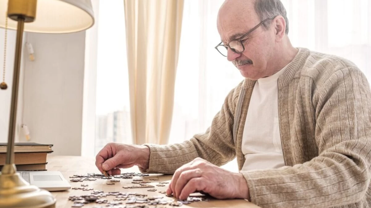 starší muž skládá puzzle