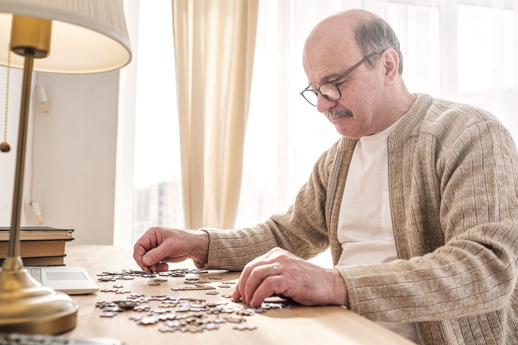 starší muž skládá puzzle