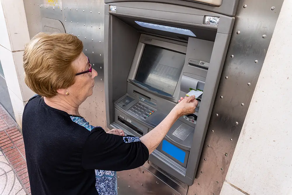 Peníze vybírejte pouze z bankomatů místních bank. - Techsvět seniorka vybírá peníze z bankomatu