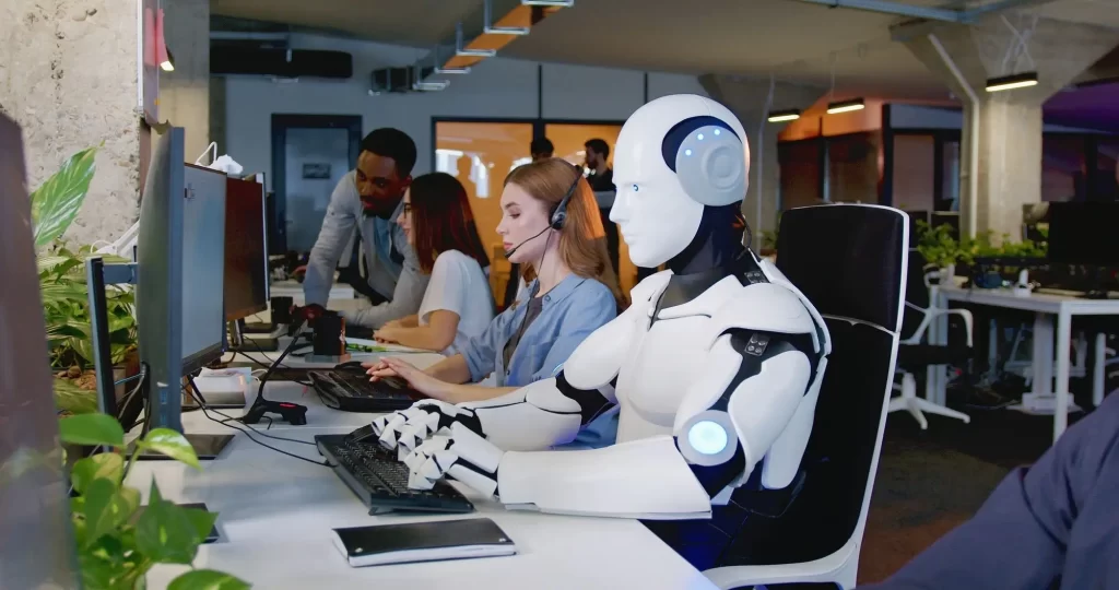 shutterstock_2229125163 - Techsvět lidé v kanceláři sedí u počítačů společně s AI robotem