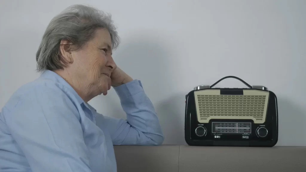 shutterstock_2253582643 - Techsvět stará žena poslouchá retro rádio