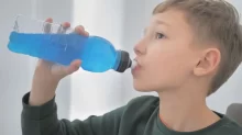 chlapec pije z lahve z modrou tekutinou