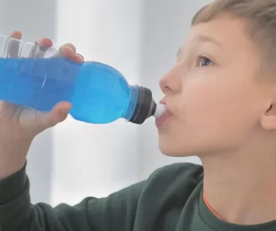 chlapec pije z lahve z modrou tekutinou