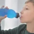 chlapec pije z lahve z modrou tekutinou