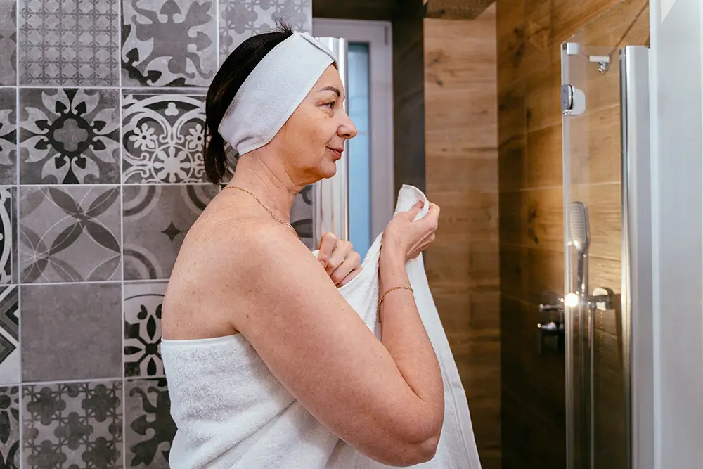 Po sprchování pokožku osušte, ale netřete ji ručníkem. Dokud je vlhká, naneste hydratační krém. - Techsvět žena po sprše