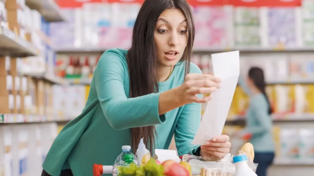 žena v supermarketu se udiveně dívá na účtenku
