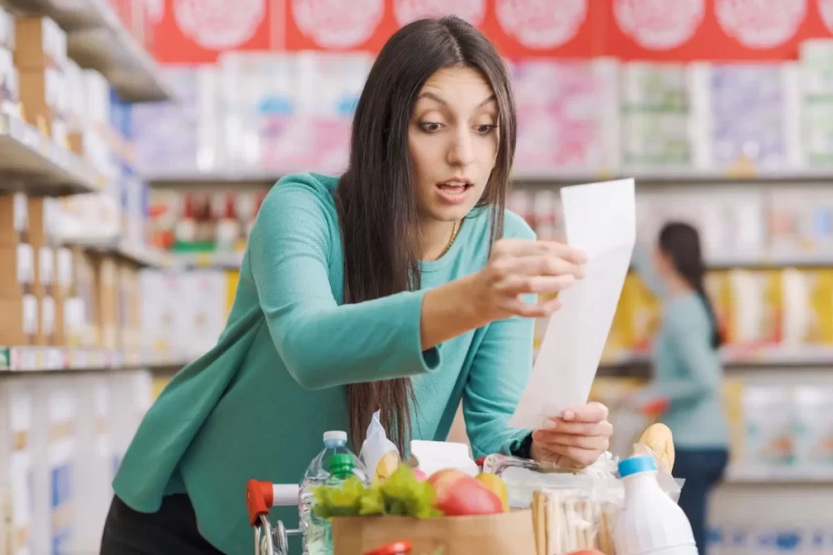 žena v supermarketu se udiveně dívá na účtenku