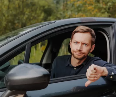 muž v autě s palcem dolů