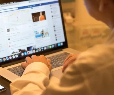 muž u notebooku, na kterém má Facebook
