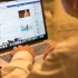muž u notebooku, na kterém má Facebook