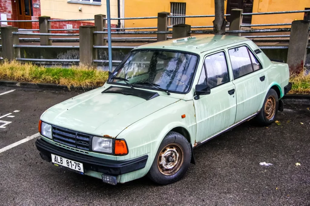 škoda druhý - Techsvět Starší Škoda 125 v původním světle zeleném laku, odstavená na ulici v obytné čtvrti.