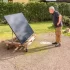 Starší muž v černém tričku se dívá na zahradě na fotovoltaický panel