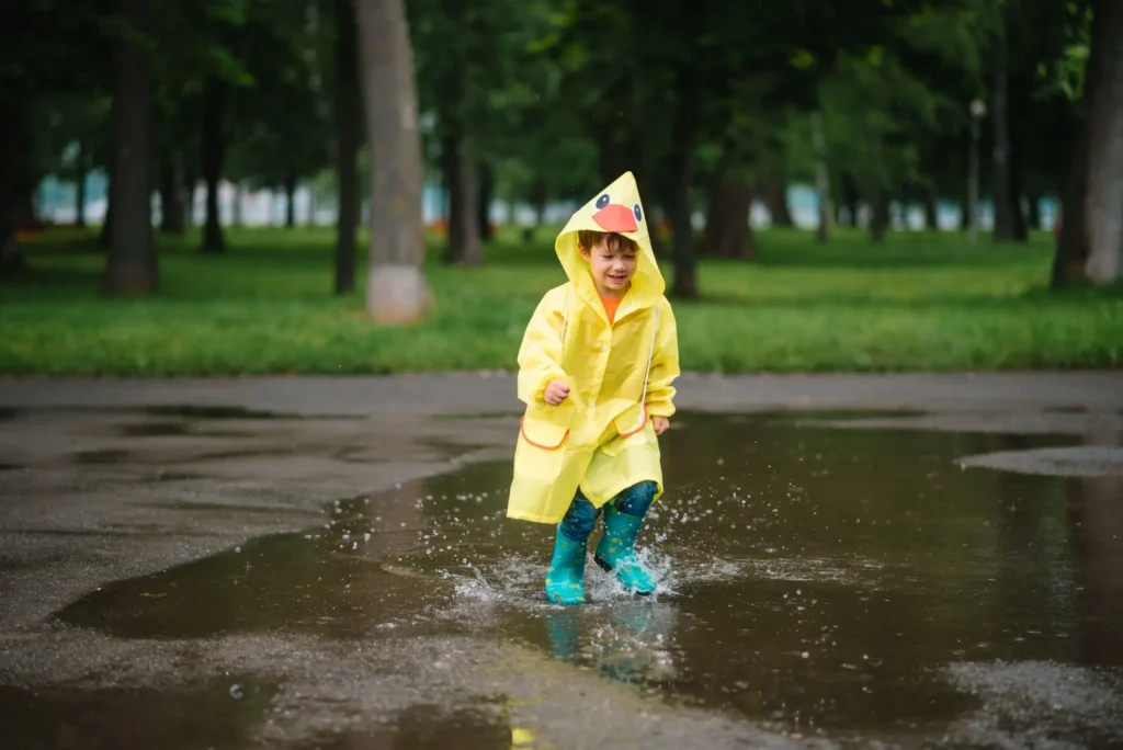 Namísto plavek a sandálů vytáhněte spíše pláštěnky, FOTO: Shutterstock - Techsvět dítě skáče v kaluži
