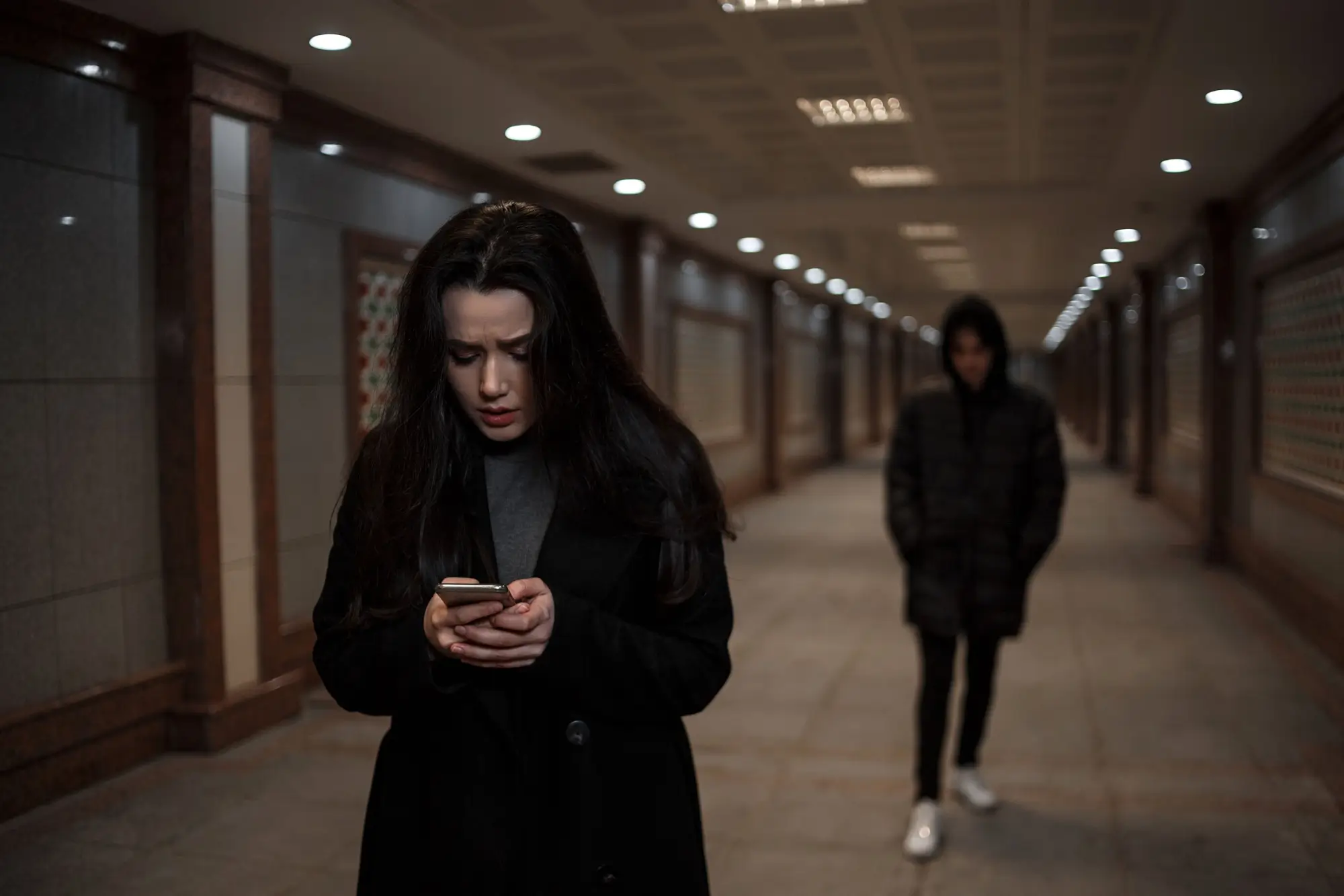 žena pronásledovaná mužem, píše na telefonu