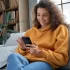Usmívající se mladá žena s mobilním telefonem