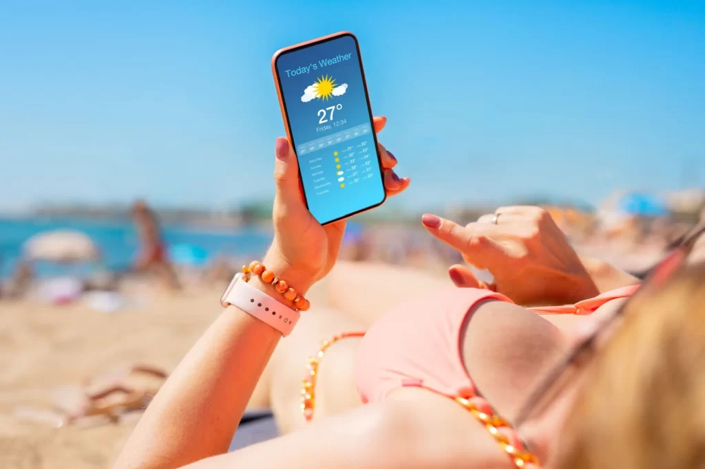 - Techsvět žena s mobilem u vody sleduje předpověď počasí