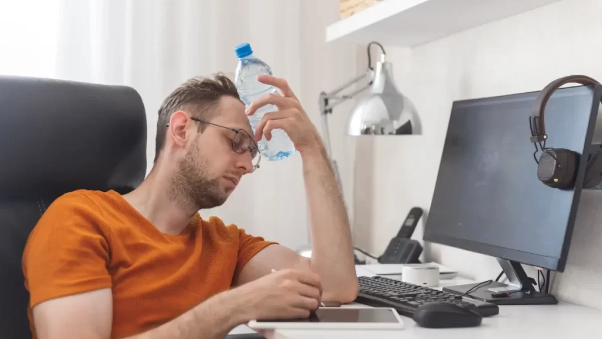 muž sedí u počítače a chladí se