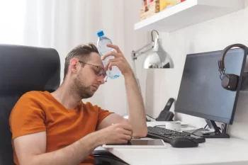 muž sedí u počítače a chladí se