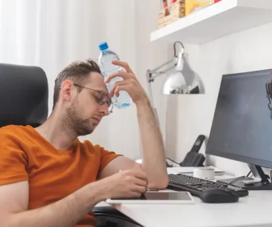 muž sedí u počítače a chladí se