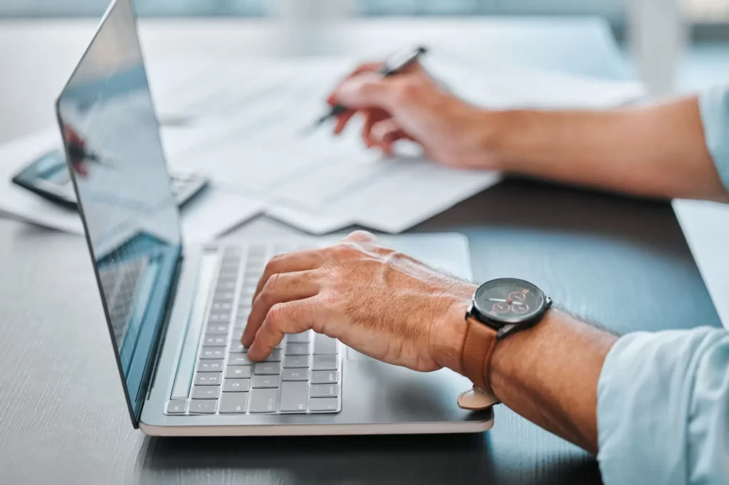 Shutterstock_2485563837 - Techsvět Ruce, laptop a papíry